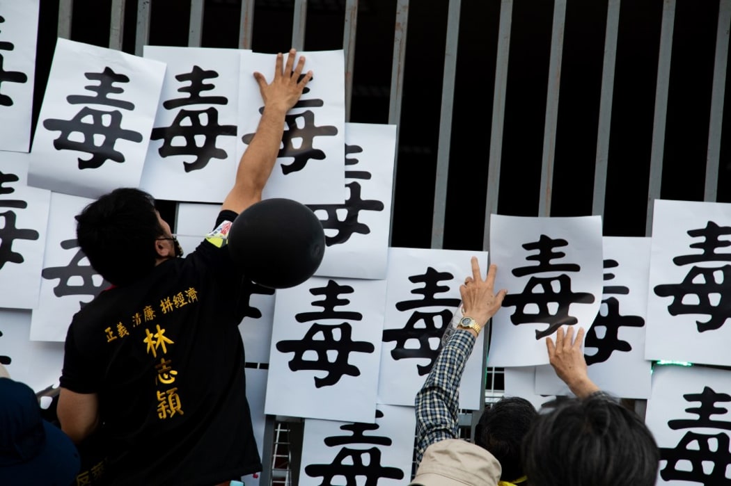 People stick the signs that read &quot;Poison&quot; on the gate in front of DPP's head quarter during a protest in Taipei, Taiwan, Nov. 22. 2020.  (Photo by Annabelle Chih/NurPhoto)
