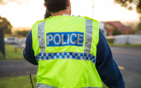 A police officer outside a cordon in South Auckland.