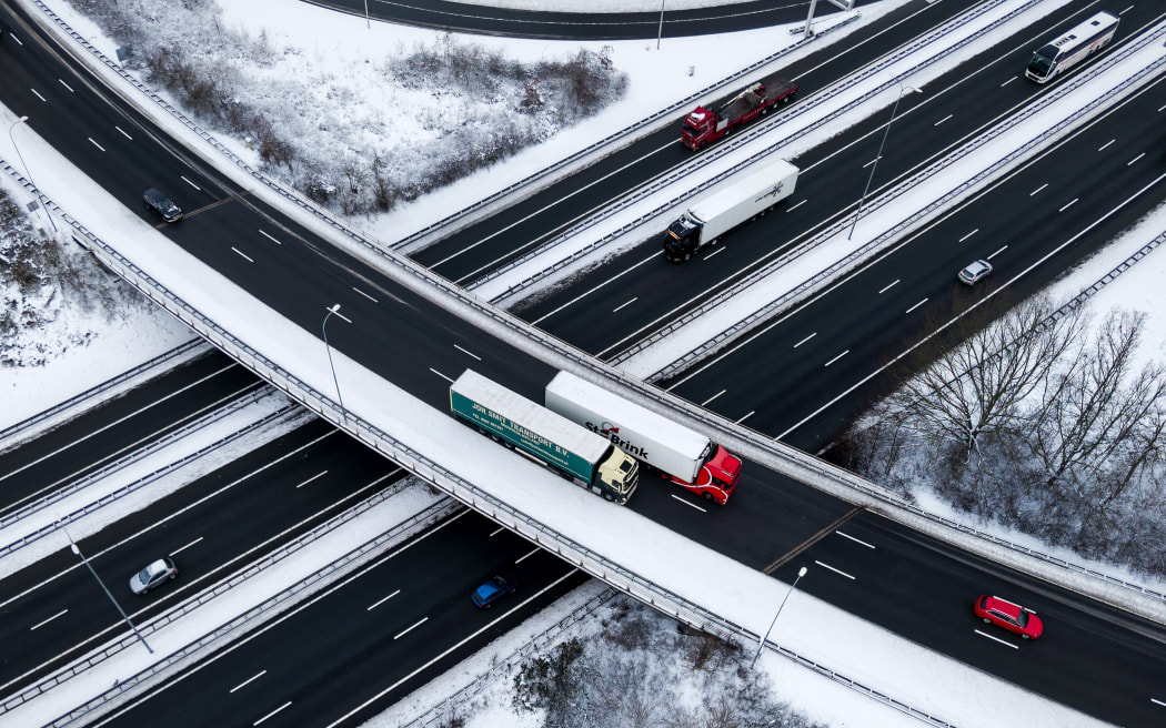 A picture taken near Utrecht on January 7, 2026 shows vehicles traveling on a highway in a snowy landscape at the Lunetten interchange. (Photo by Robin van Lonkhuijsen / ANP / AFP) / Netherlands OUT / NETHERLANDS OUT / NETHERLANDS OUT