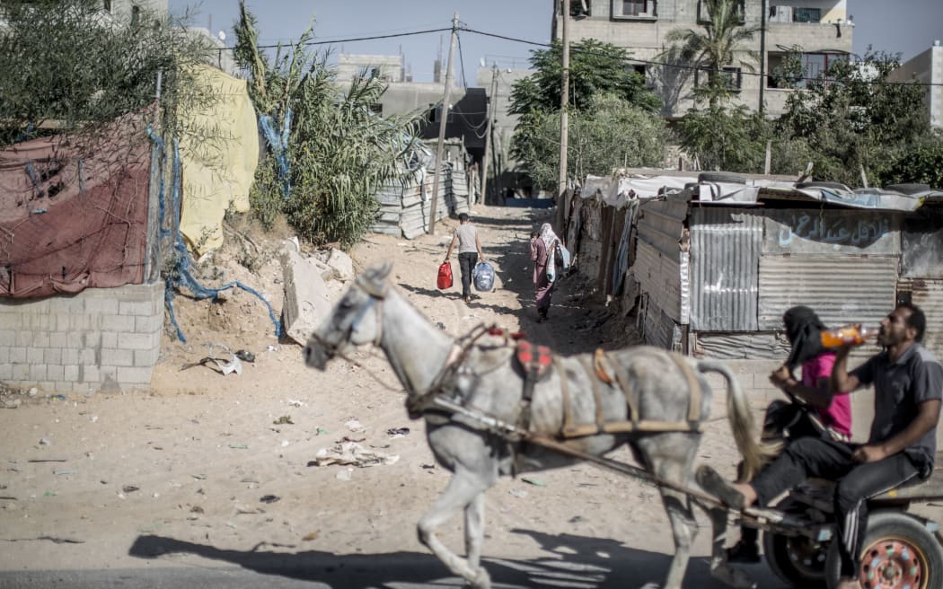 Palestinians carry belongings as they return home in the al-Atatra area in the northern Gaza Strip.