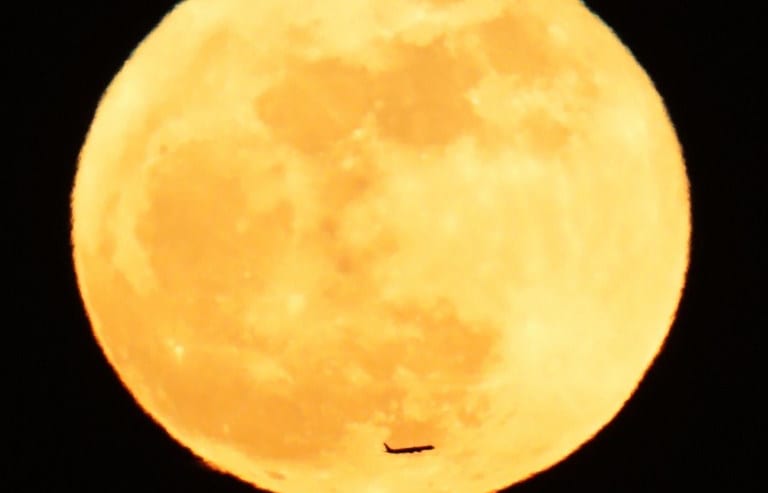 An airplane passes across a full moon in the night sky over Tokyo on Jan. 2, 2018. The phenomenon of "supermoon'' happened when the orb was the closest point to the earth and looked larger than usual.