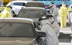 Medical staff wearing protective gear at a "drive-through" virus test facility in Goyang, north of Seoul, 29 February 2020.