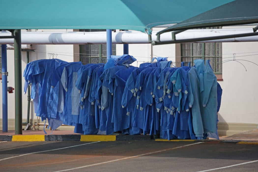 Personal Protective Equipment (PPE) are hung next to tents dedicated to the treatment of possible Covid-19 coronavirus patients at the Tshwane District Hospital in Pretoria on July 10, 2020.