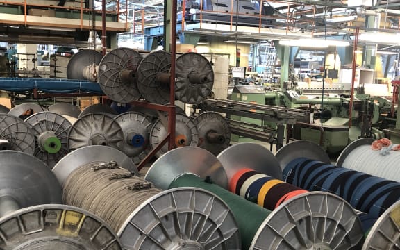 Big spools of yarn on the factory floor.