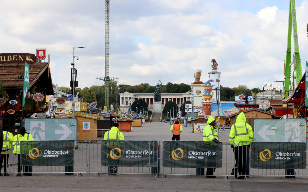 Security officers stand in front of the empty Theresienwiese grounds of the Oktoberfest beer festival on 1 October, 2025 in Munich, southern Germany, after the festival was closed over a bomb threat.