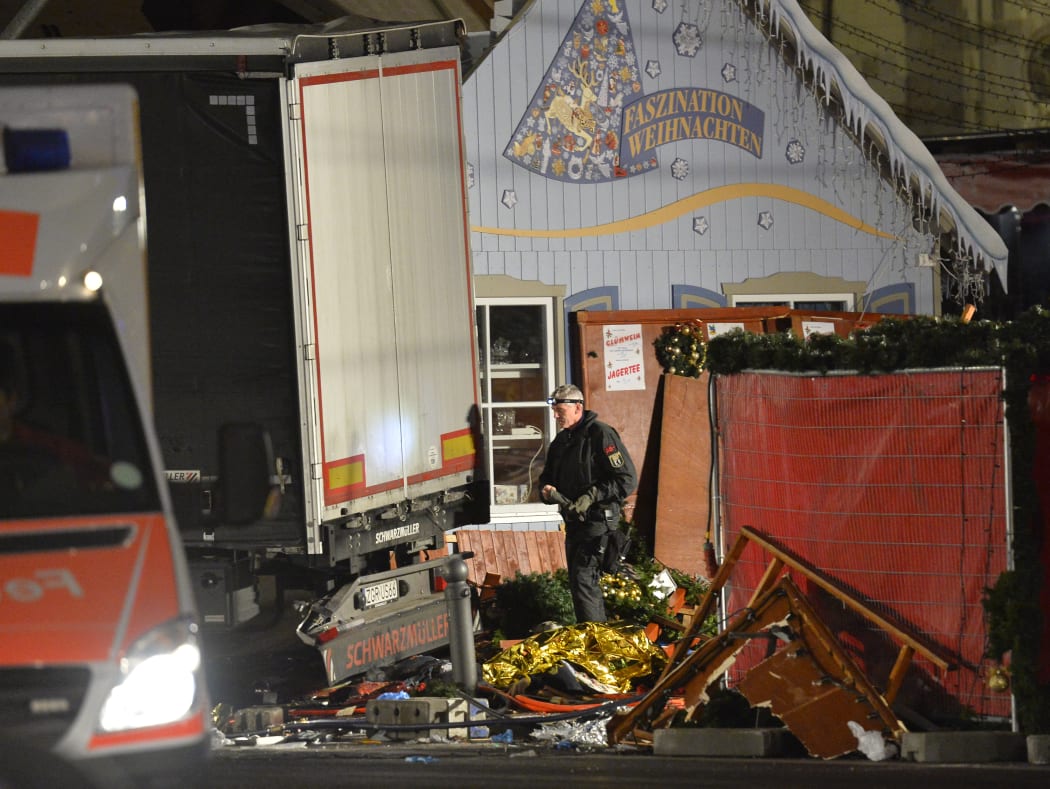 An officer inspects the truck after it crashed into a crowd near a Christmas market in Berlin.