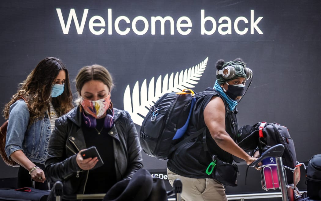Passengers wearing face masks arrive from New Zealand at Sydney under the one-way rule bubble.