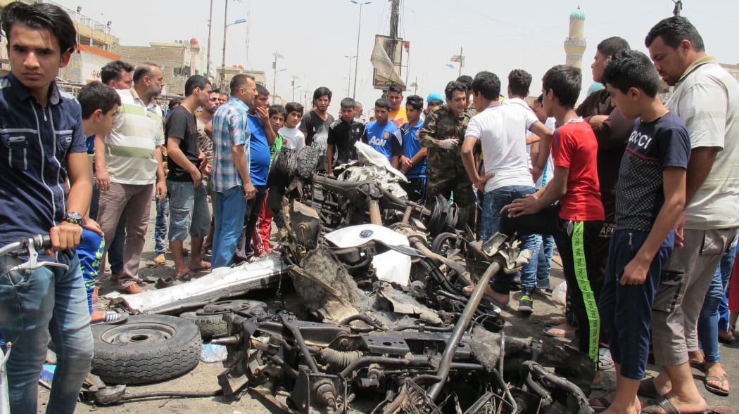 People gather at the site of an explosion in Uraiba marketplace, Sadr City, Baghdad.