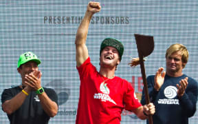 Zane Schweitzer displays the trophy presented by Laird Hamilton (right)
