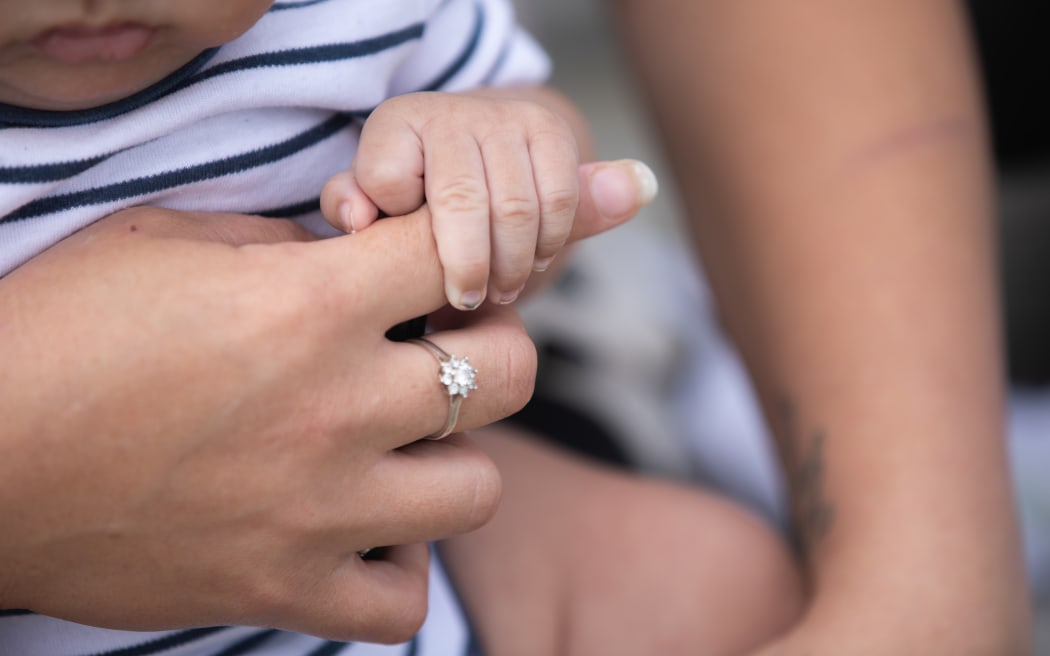 Mariska Kruger's youngest son sits on her lap, his hand wrapped tightly around her index finger.