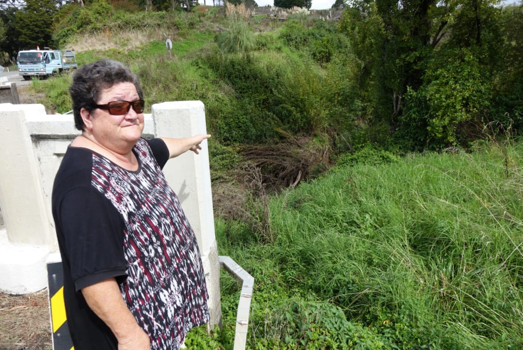 Sharon Kaipo points to debris in Mangakahia stream ... neither forestry companies nor the regional council are interested in removing it, she says.