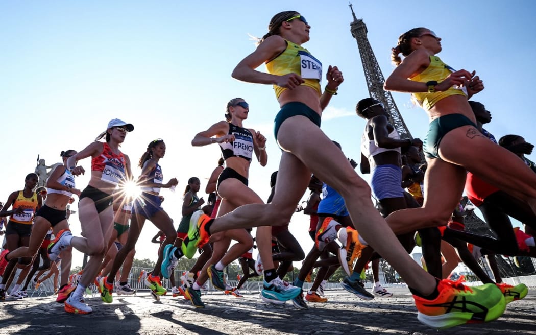 New Zealand's Camille French (C) and the rest of athletes run past Eiffel Tower, as they compete in the women's marathon of the athletics event at the Paris 2024 Olympic Games in Paris on August 11, 2024. (Photo by Anne-Christine POUJOULAT / AFP)