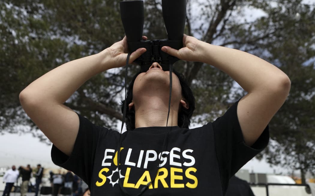 A man looks toward the sky as the moon begins to partially eclipse the sun in Ciudad Juarez, Chihuahua State, Mexico on April 8, 2024.