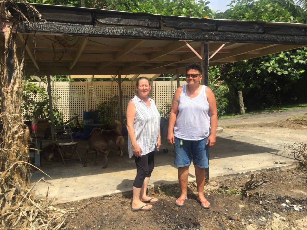 Tina Daly at left and Moana Matapo and the fire damaged car port — all that was left after a fire destroyed their home and contents.