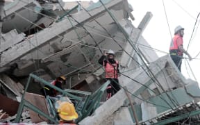 Palestinian journalists stand in shock following the destruction of Jala Tower, which was housing international press offices, by an Israeli airstrike in the Gaza Strip on May 15, 2021.