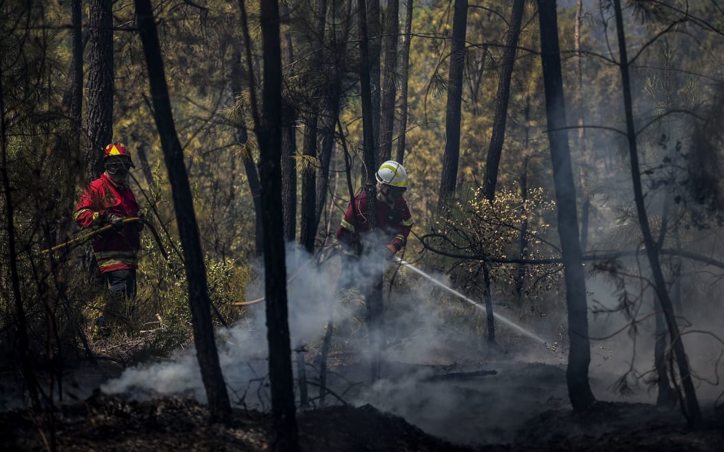 A firefighter tackles a wildfire near a house in Sarnadas, Macao, in central Portugal on July 21, 2019.