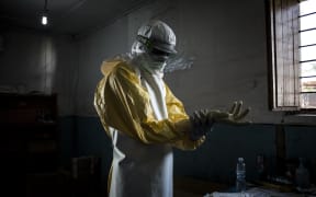 A health worker puts on protective equipment before entering the red zone of a MSF (Doctors Without Borders) supported Ebola Treatment Centre.