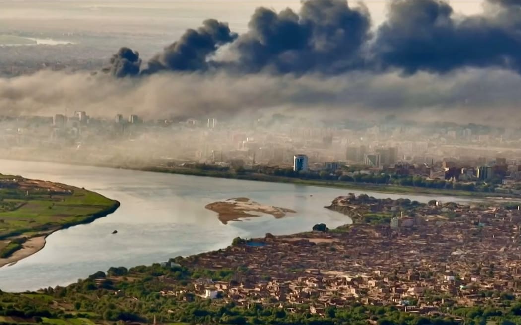 This video grab taken from AFPTV video footage on 19 April, 2023, shows an aerial view of black smoke covering the sky above the capital Khartoum.