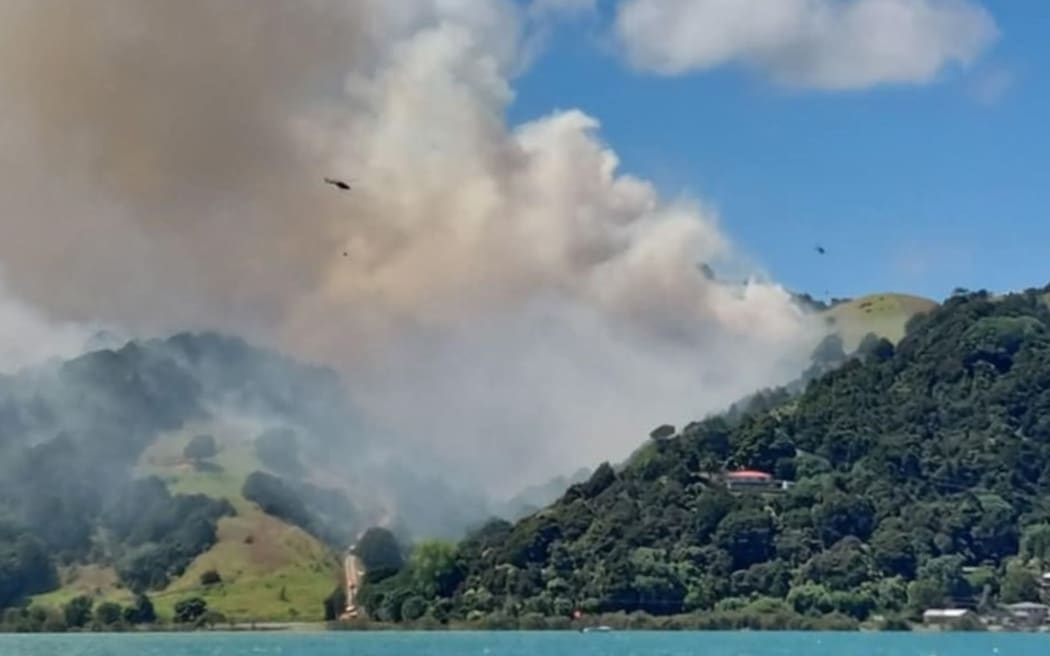 Helicopters battle the fire in a valley between Onerahi and Tamaterau, Whangārei.
