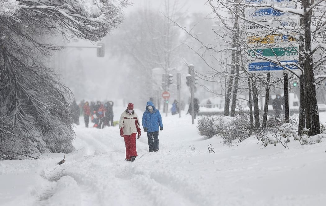 MADRID, SPAIN - JANUARY 09: People walk on snow covered road as they enjoy during heavy snowfall in Madrid, Spain on January 09, 2s021.