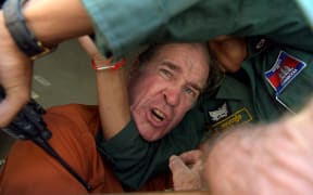 Australian filmmaker James Ricketson reacts as he attempts to speak to journalists from a prison vehicle after his verdict at the Phnom Penh court.