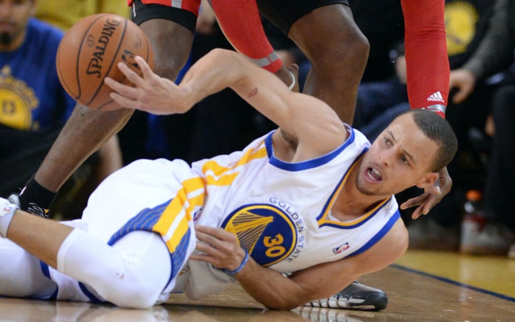 The Golden State guard Steph Curry fights for the ball on the floor.