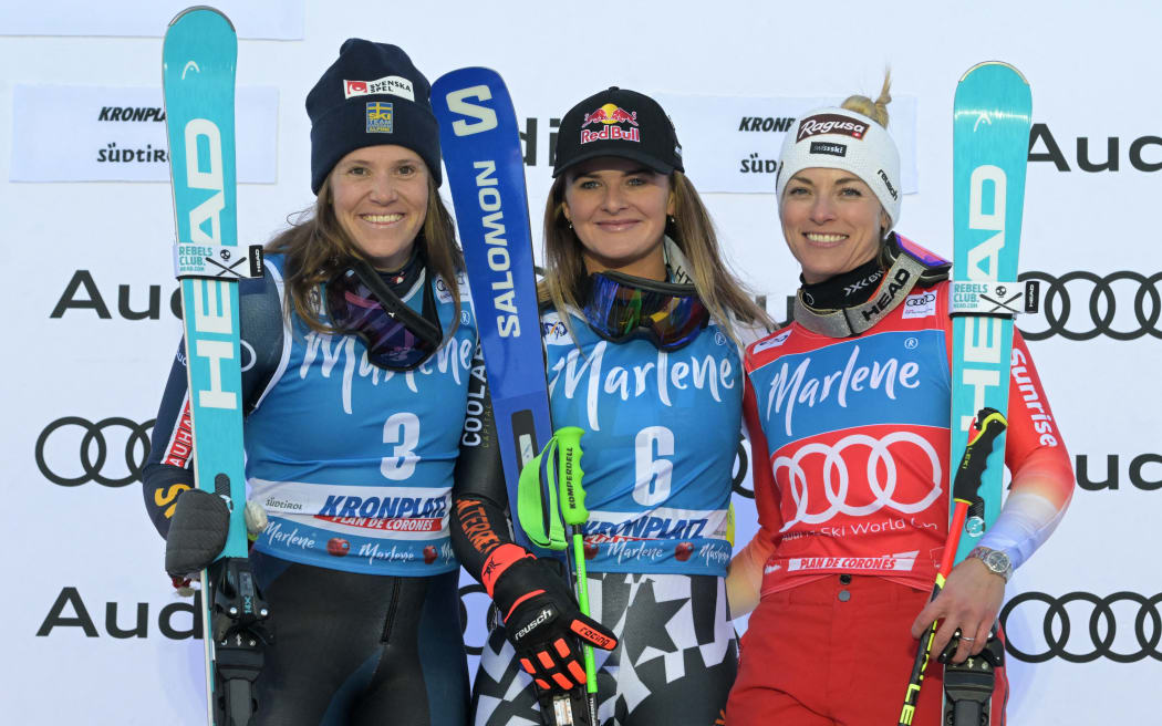 Switzerland's Lara Gut-Behrami (R), winner, New Zealand's Alice Robinson (C) and Sweden's Sara Hector (L), both second with the same clock, pose during the podium ceremony of the Women's Giant Slalom event of FIS Alpine Skiing World Cup in Kronplatz, Plan de Corones, Italy on January 30, 2024. (Photo by Tiziana FABI / AFP)