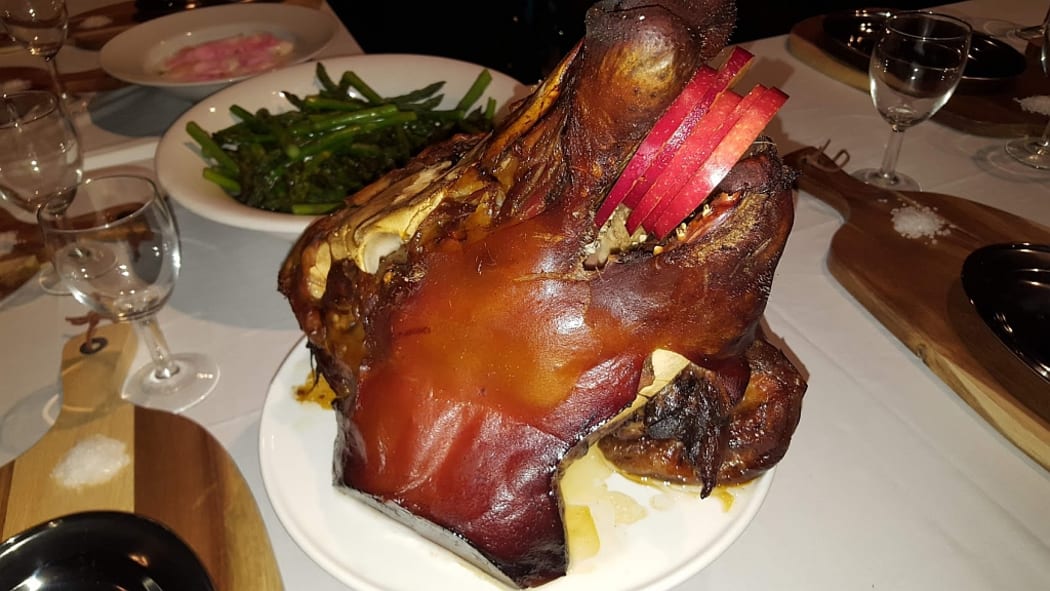 An image of a baked Pig's head displayed on a table at the Symposium of Gastronomy.