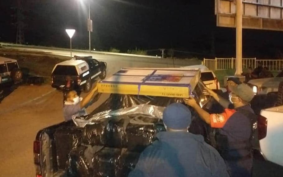 PNG police loading cartons of seized cocaine.