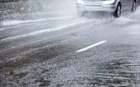 Car driving in heavy rain. Street flooding.