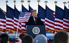 President Donald Trump speaks to supporters at Joint Base Andrews before boarding Air Force One for his last time as President.
