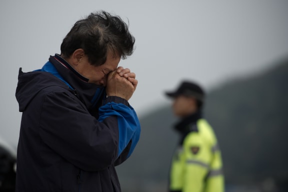 A man waits a Jindo harbour where families of the missing are gathered.