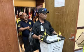 Police officers bring ballot boxes into the International Conference Center election tabulation HQ from the polling stations following their 7.00pm closing Monday, 20 November 2023.