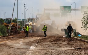 Israeli emergency services clear a road outside Israel's Ben Gurion airport after a missile launched from Yemen struck near the facility on May 4, 2025.