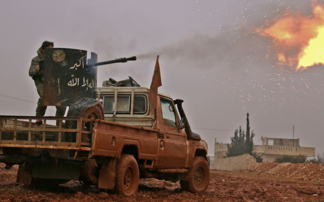 Syrian opposition fighters fire towards positions held by Islamic State group jihadists in al-Bab.