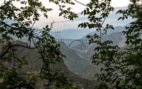 This photograph taken on July 6, 2024, shows a general view of Chenab bridge, the world's highest rail arch bridge in Reasi, Jammu and Kashmir. Soaring high across a gorge in the rugged Himalayas, a newly finished bridge will soon help India entrench control of disputed Kashmir and meet a rising strategic threat from China. (Photo by Tauseef MUSTAFA / AFP)