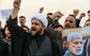 03 January 2020, Iraq, Baghdad: Supporters of the predominantly Shia Muslim Popular Mobilization Forces (PMF) shout slogans during an anti-US protest after the US airstrike in Baghdad that killed Qassem Soleimani,