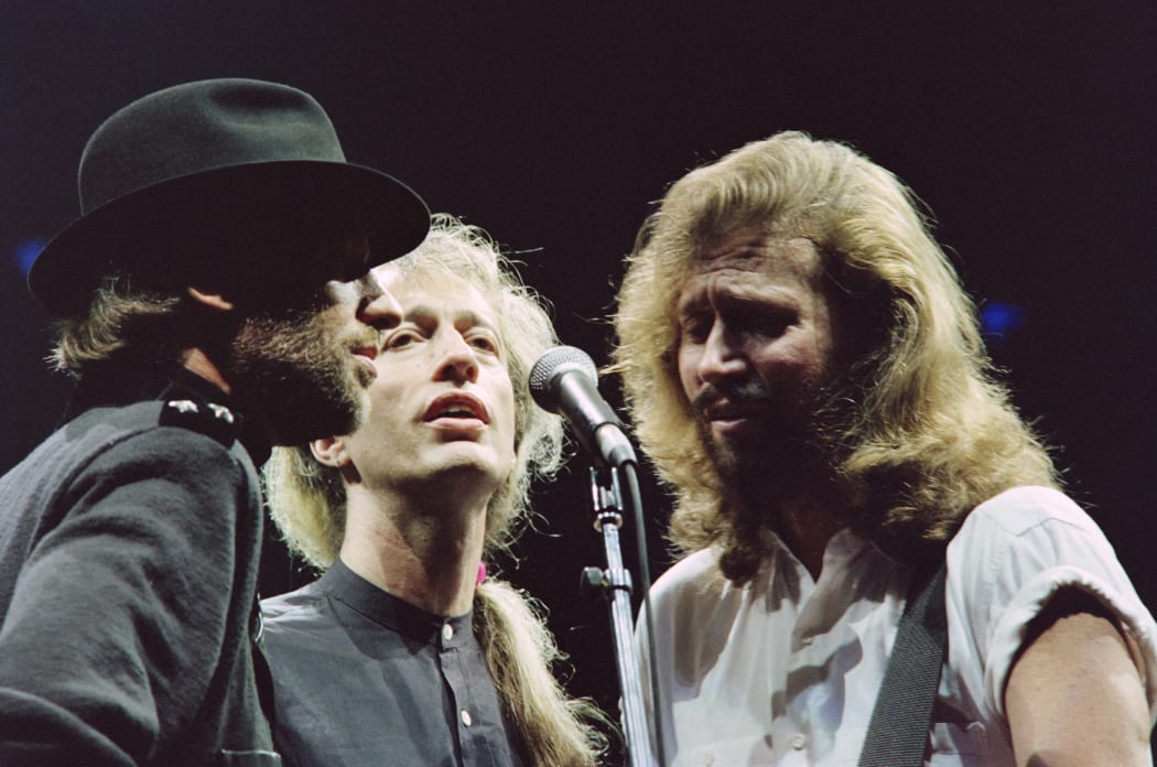 British band Bee Gees singer, Robin Gibb (C), flanked by his two brothers Maurice (L) and Barry (R), sings during a concert at Paris Bercy on June 23, 1991. Gibb, 62, died on May 21, 2012 after a lengthy battle with cancer. AFP PHOTO / BERTRAND GUAY (Photo by BERTRAND GUAY / AFP)