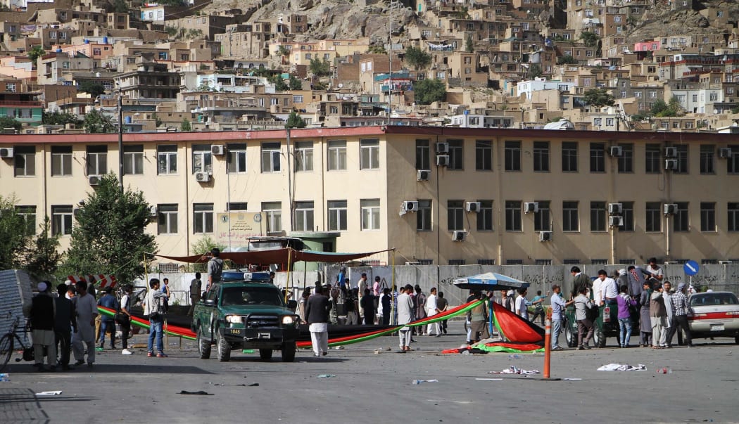Afghan protesters from Hazara minority stand at the blast site after a suicide attack in Kabul, Afghanistan.
