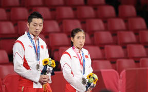 Xu Xin and Liu Shiwen of China react during the ceremony for the table tennis mixed doubles gold medal match at the Tokyo 2020 Olympic Games.