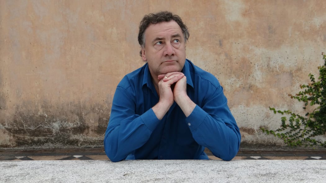 Musician Matthew Bannister looking pensive while leaning on a wall