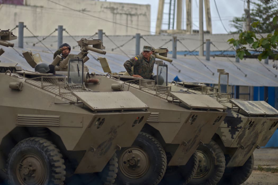 Soldiers remain inside armoured vehicles outside the Guayas 1 Center for the Deprivation of Liberty (Litoral Penitentiary) in Guayaquil, Ecuador, on 13 November, 2021, after a riot occurred. Ferocious clashes have left 68 inmates dead, police said.