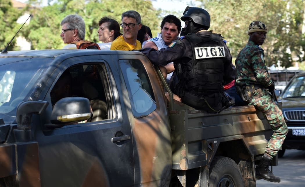 Ivorian security forces evacuate people after heavily armed gunmen opened fire on March 13, 2016 at a hotel in the Ivory Coast beach resort of Grand-Bassam.