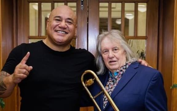 Roger Fox and King Kapisi standing in front of a door.