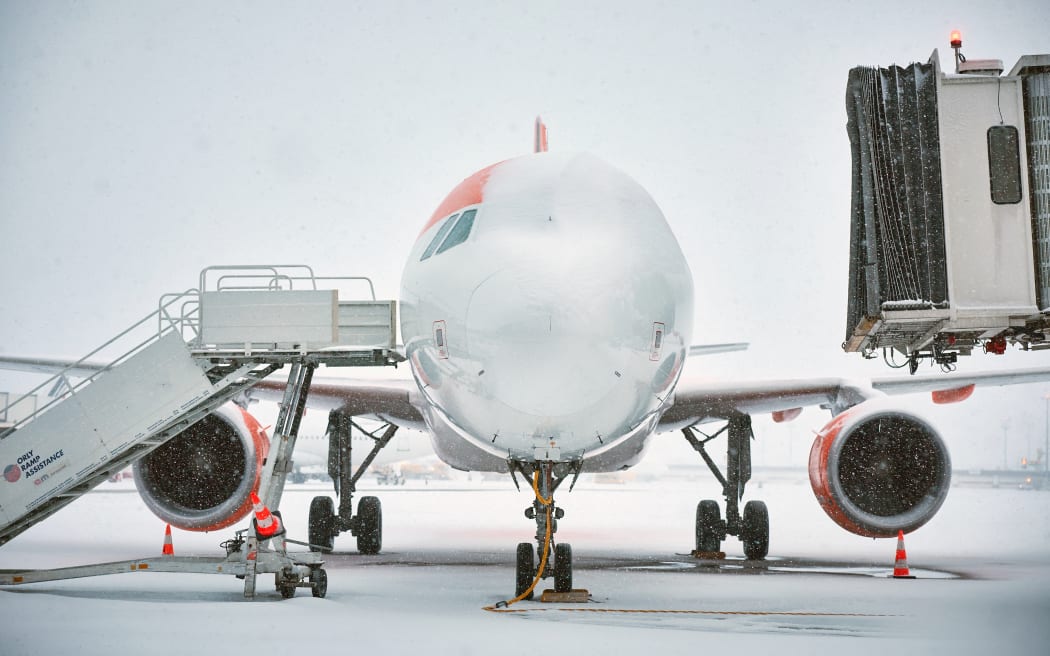 This photograph shows a airplane from low cost airline company EasyJet covered with snow during heavy snowfalls which cause flight cancellations at Orly Airport, south of Paris on January 7, 2026. 40% of flights are expected to be cancelled at Paris-Charles-de-Gaulle (CDG) airport and 25% at Orly airport, as snow disrupts air, rail and road traffic across the country, French Transport Minister announced on January 6, 2026. (Photo by Kiran RIDLEY / AFP)
