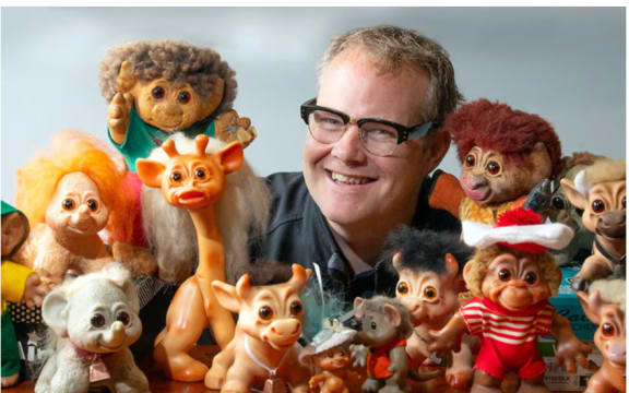 Damian Sutton is surrounded by his Trolls collection.