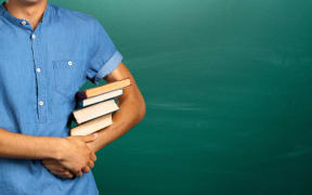 young man holding books