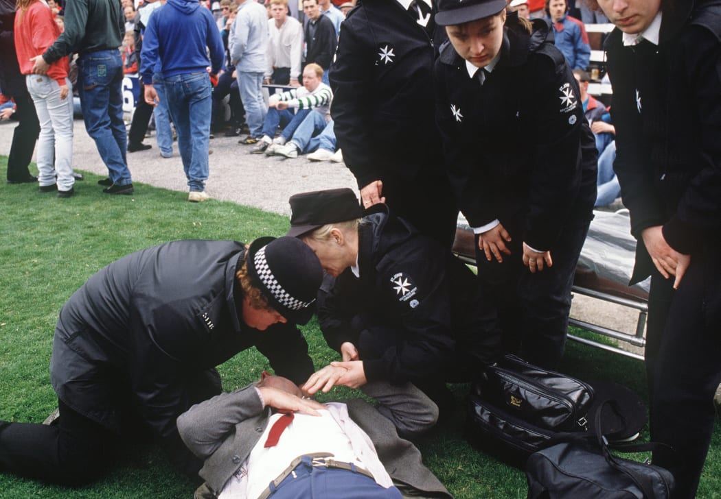 Emergency sevices personnel attendi to soccer fans at Hillsborough stadium, where 96 fans were crushed to death and hundreds injured in April 1989.