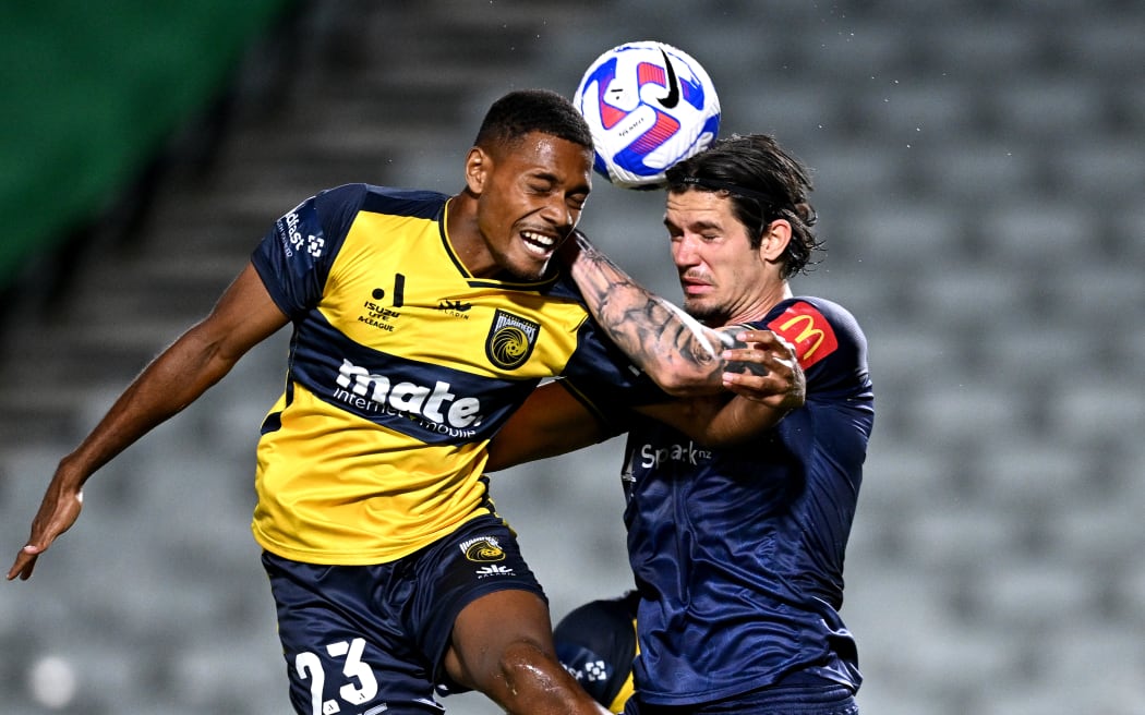 Dan Hall of the Mariners competes to head the ball with Oskar Zawada of the Phoenix