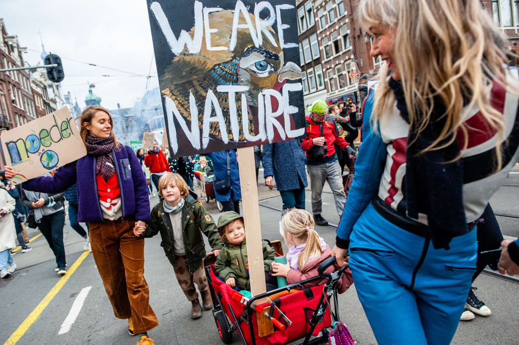 Two women transporting their children in a cargo bike during a massive Climate march organized in Amsterdam, on 6 November  2021.